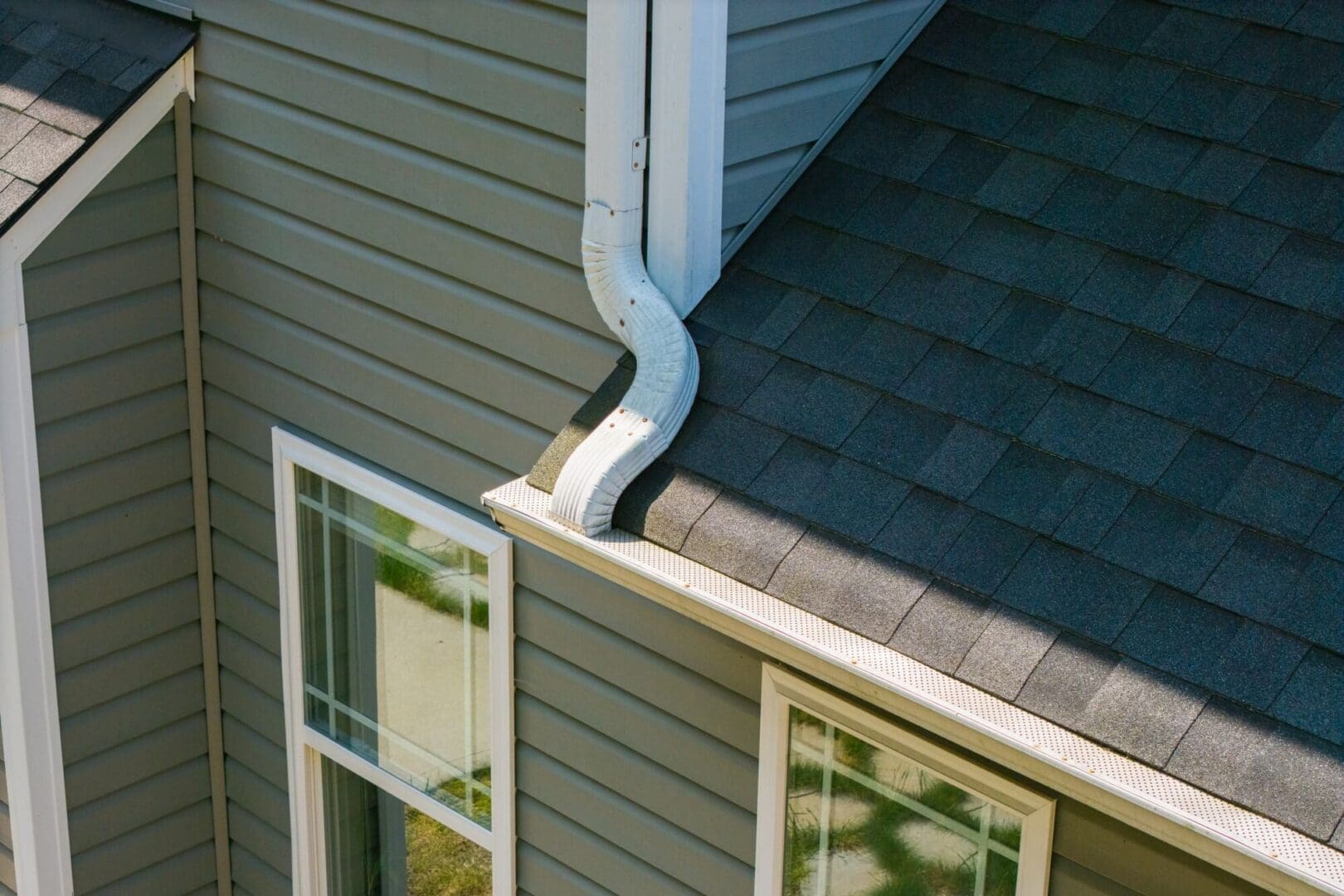 House roof with gutter and windows visible.