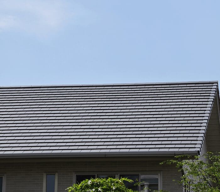 House with sloped roof and blue sky.