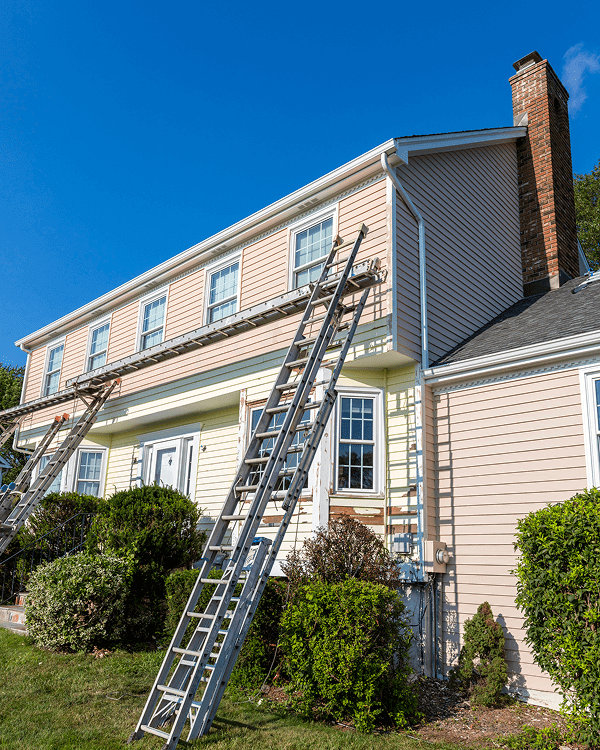 House exterior with ladders for painting.