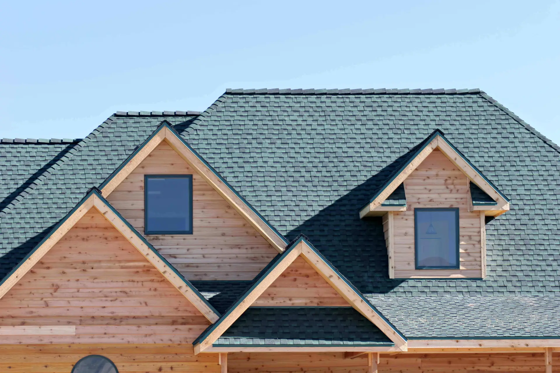 Wooden house with green shingle roof design